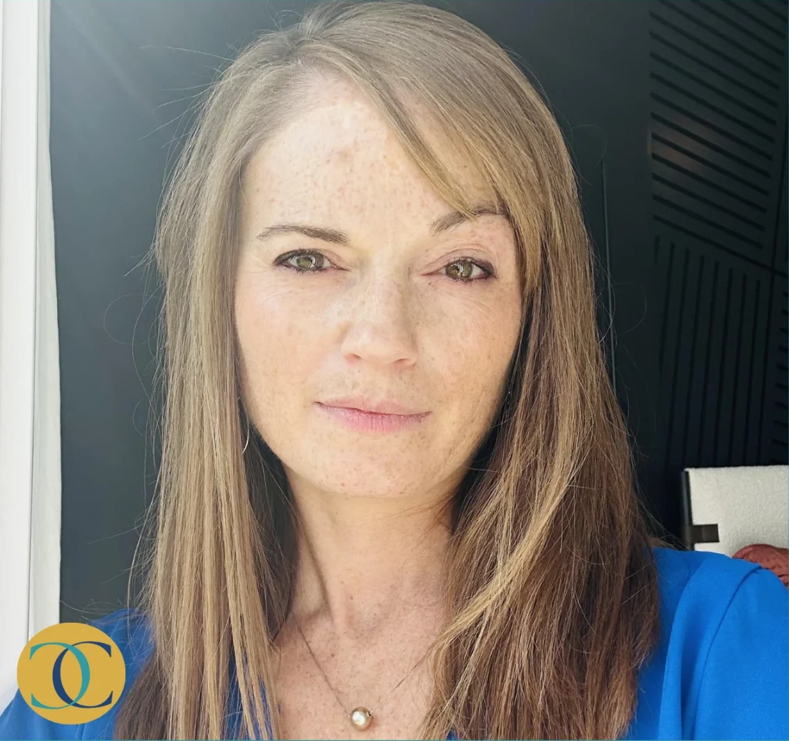 A close-up portrait of a woman with long brown hair, wearing a blue top and a pearl necklace, looking directly at the camera with a calm expression. Chirosconnect